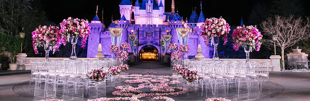 An aisle decorated with rose petals leading towards Sleeping Beauty Castle