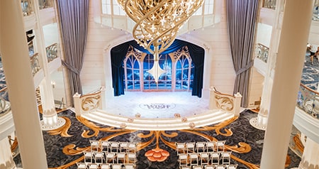A large ornate chandelier inside the Grand Hall on board the Disney Wish cruise ship