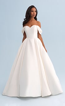 A woman wearing a off the shoulder wedding dress with a full skirt
