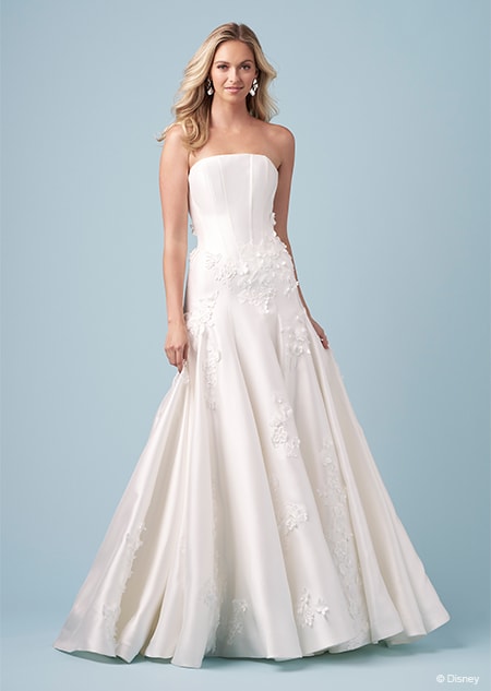 A bride wearing a strapless Aurora inspired A line gown with embroidered flowers