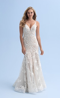 A bride in a form fitting wedding dress with a deep neckline decorated with crystal flowers