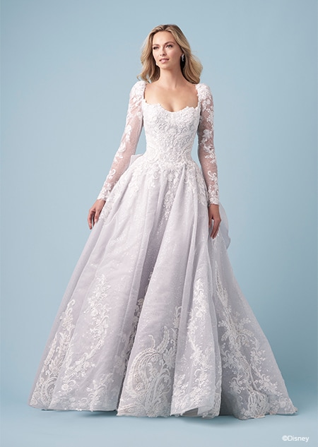 A bride wearing a Cinderella inspired A line wedding gown featuring embroidery, long lace sleeves and a semi sweetheart neckline