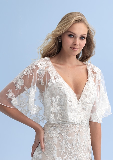 A bride wearing a see thru shall with crystal flowers over her wedding dress A bride wearing a see thru shall with crystal flowers over her wedding dress