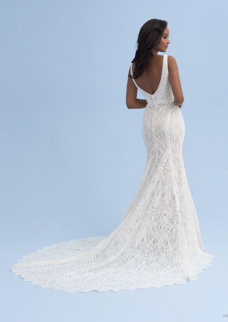 The back view of a bride in a lace dress with thick straps and a long train