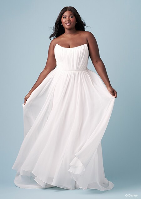 A bride wearing a strapless Jasmine inspired sheath gown featuring a scoop neckline