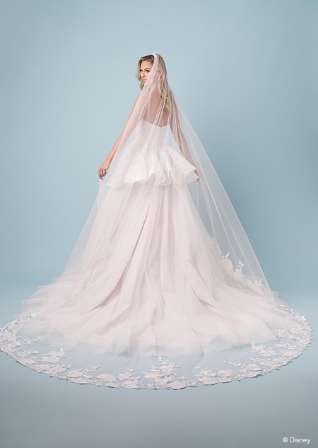 The back of a bride wearing a strapless Rapunzel themed ball gown featuring a sweetheart neckline and a long sheer veil