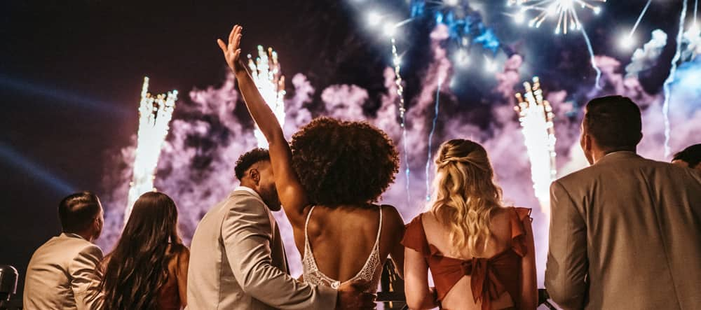 A wedding party enjoys a fireworks show in EPCOT