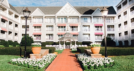 An outdoor wedding ceremony venue at Disney’s Yacht Club Resort, with a path leading to a gazebo, surrounded by flowers