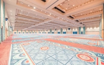 A very large ballroom with colorful carpeting and decor themed to the beauty of Spanish, Mexican and American Southwestern influences.