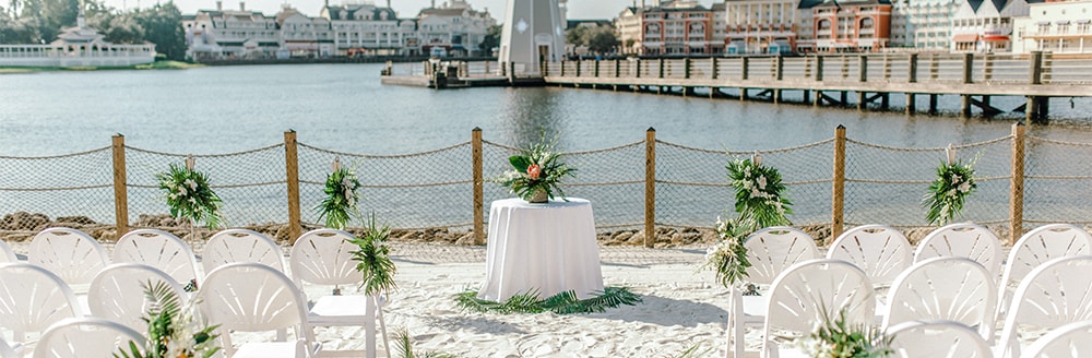 A round table on a beach in front of a lighthouse and Disney’s BoardWalk