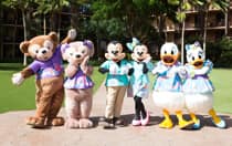 Duffy, ShellieMay, Mickey Mouse, Minnie Mouse, Donald Duck and Daisy Duck wearing Hawaiian shirts and dresses while posing in front of Aulani, a Disney Resort & Spa