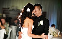 A bride and groom dance in front of their guests