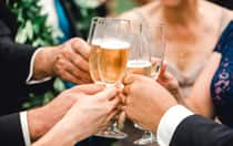 The hands of wedding Guests toasting with champagne flutes