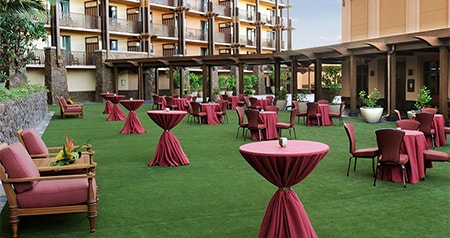 A fancy setting of dining and cocktail tables on the lawn of Aulani, a Disney Resort and Spa