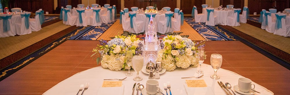 A table arrangement of a castle and bouquet for the bride and groom in a ballroom