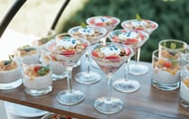 A table presentation with different styles of cocktail glasses filled with artful parfait and overnight oats