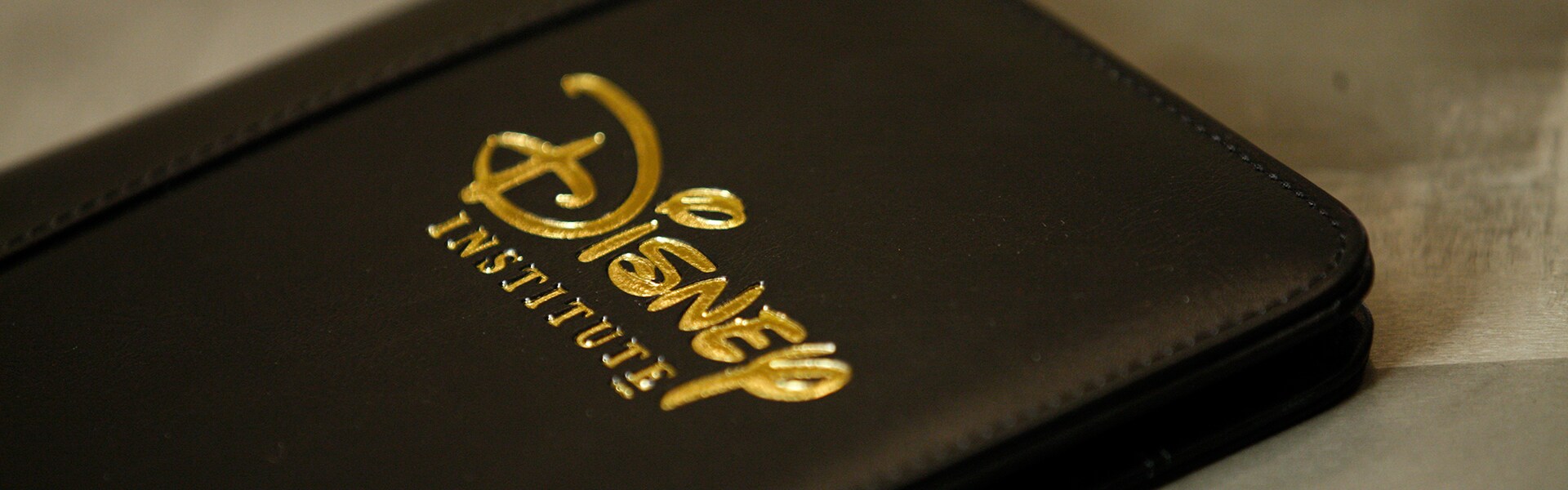 A hard bound notebook debossed with a Disney Institute logo