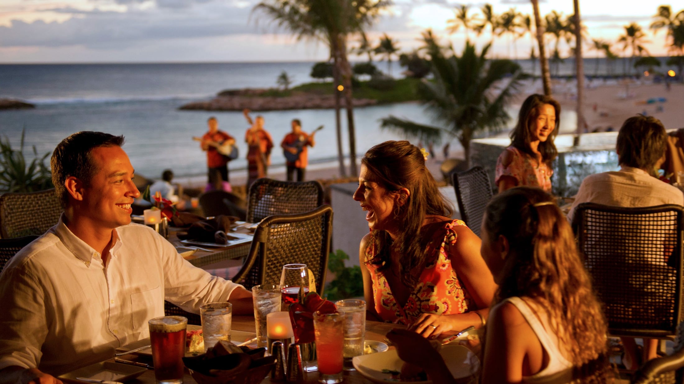 Families dining on a beachside patio at Aulani Resort