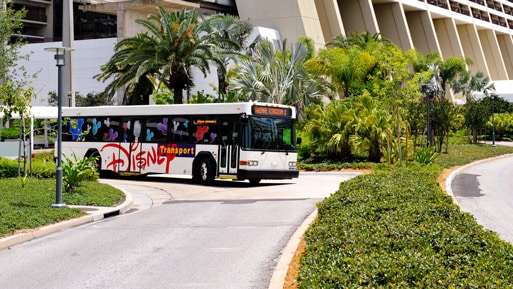 A Disney transport bus driving on a road near Disney's Contemporary Resort