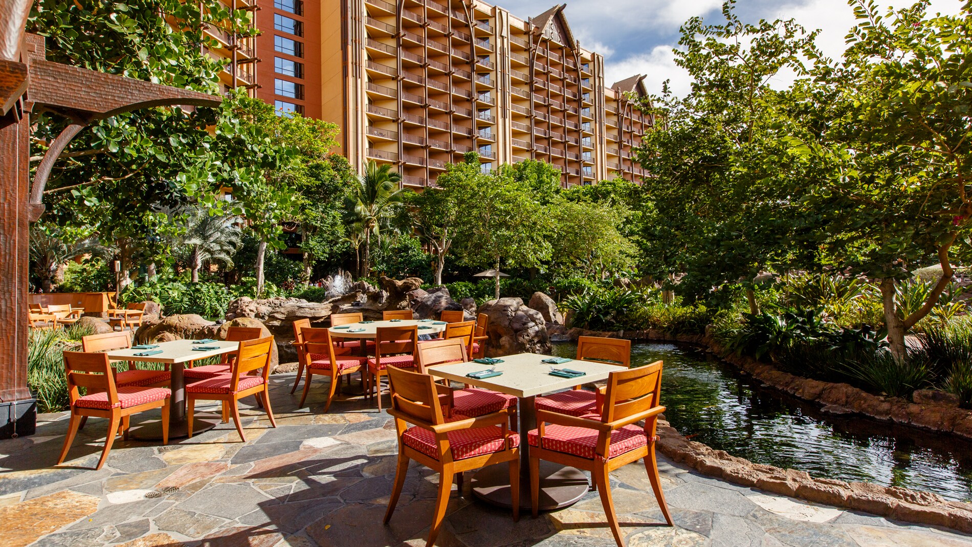 An outdoor dining area overlooking a small pond at Aulani Resort