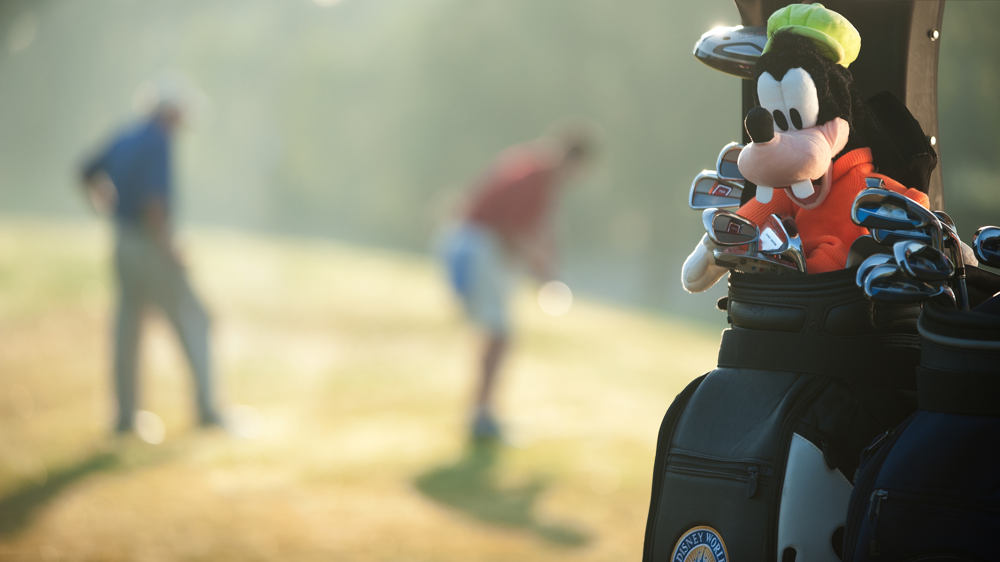 A golf bag with a plush Goofy golf club headcover