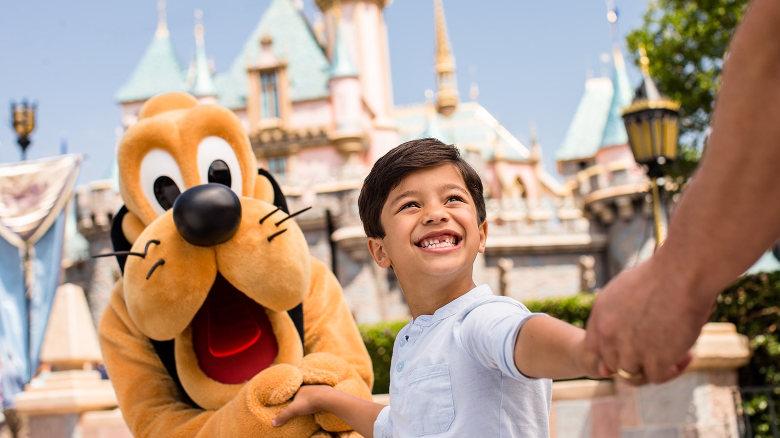 Pluto with boy in front of Sleeping Beauty's Castle