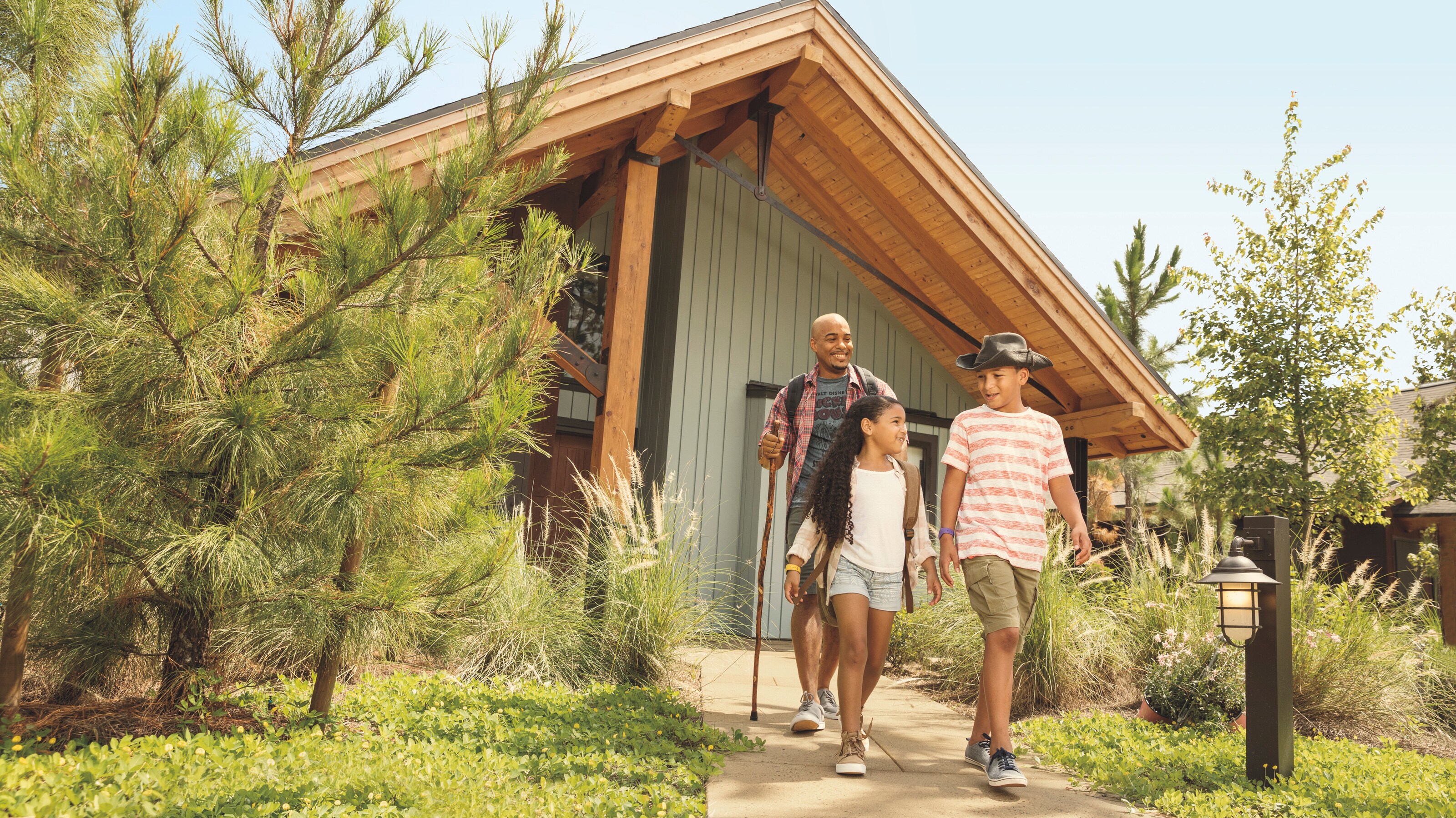 A father, son and daughter walking at the entrance to their vacation Cabin