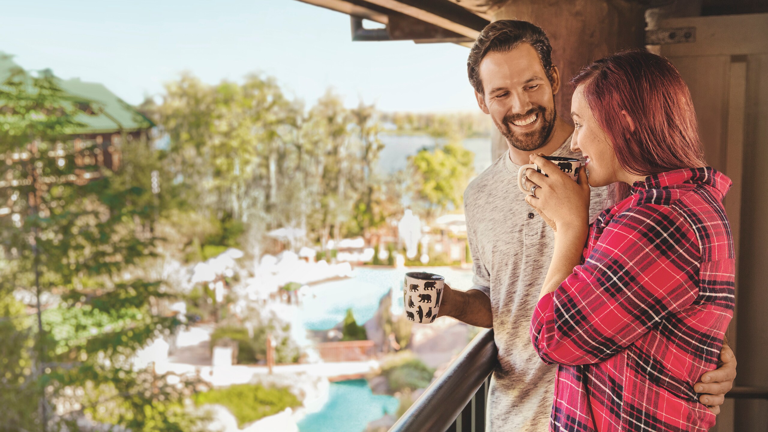 A man and woman sipping coffee while standing on the balcony of their Resort villa