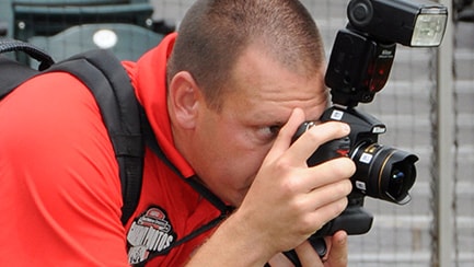 A photographer looking through the viewfinder of his camera