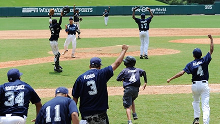 Several baseball players on a field, raising their arms in celebration