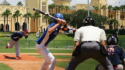 A baseball player pitching a ball to a batter