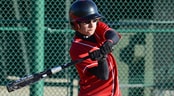 AAU Summer Baseball Event A teenage baseball player swings his bat